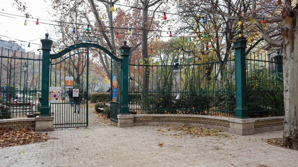 a gated area with a brick walkway and a green gate