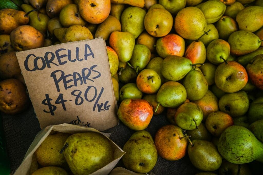 Close-up of Corella pears with price tag at a market, showcasing their fresh and juicy appeal.