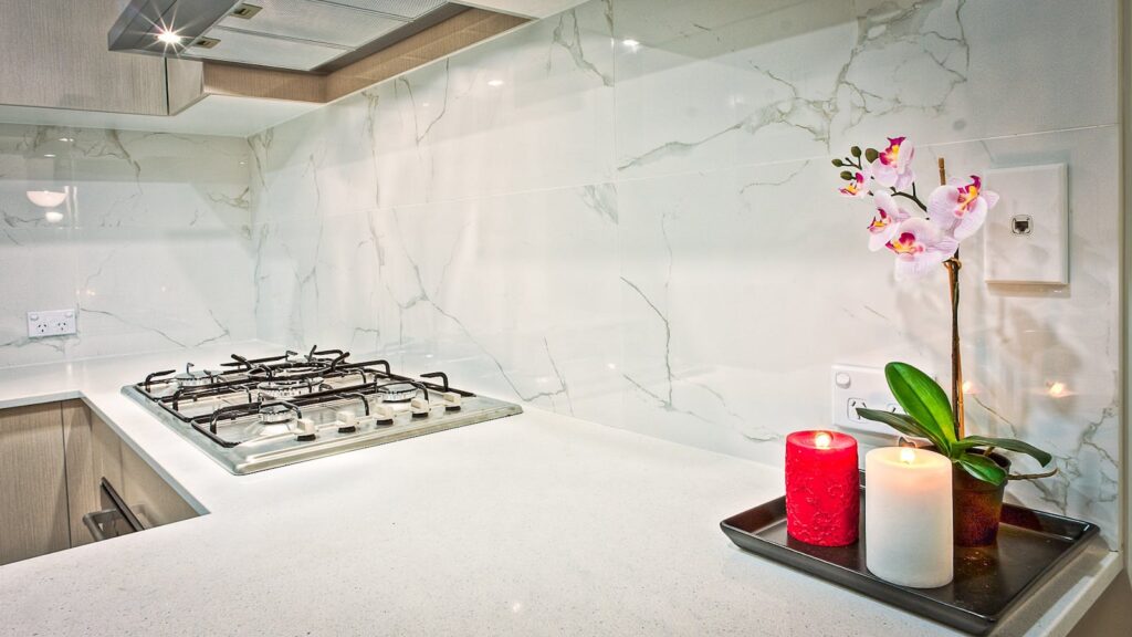 Stylish kitchen interior featuring decorative candles and orchids on a countertop.